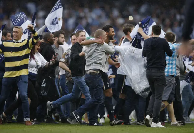 Fans run onto the pitch