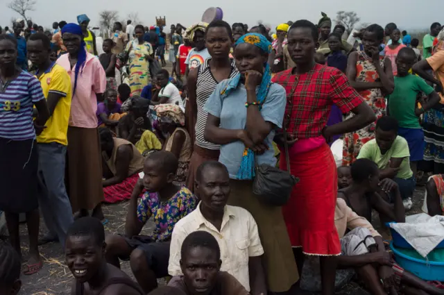 Refugees queue at a World Food Programme (WFP) food distribution site at a refugee settlement on February 25, 2017 in Palorinya, Uganda