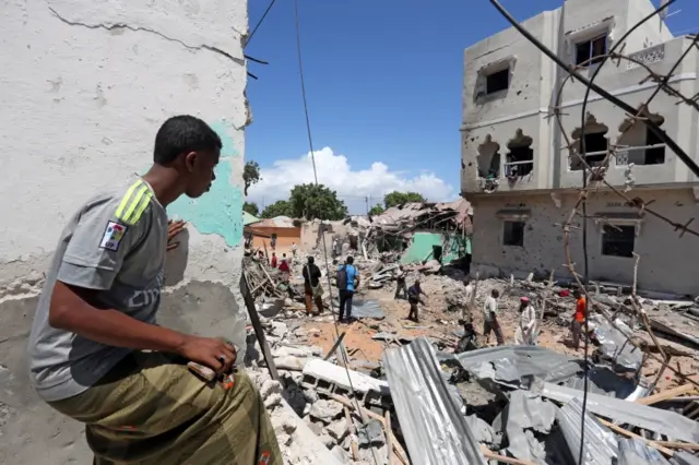 A Somali man watches the damage caused at the scene where a car exploded in the Madina district of Mogadishu