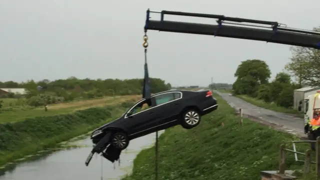 Car being pulled from river