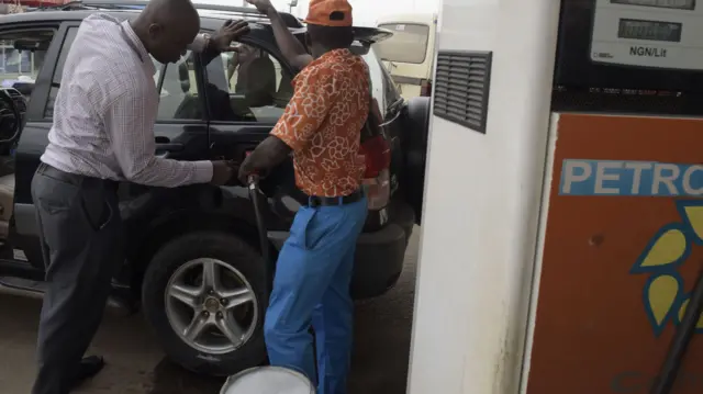 An attendant sells fuel to a motorist at a filling station in Lagos, on May 12, 2016.