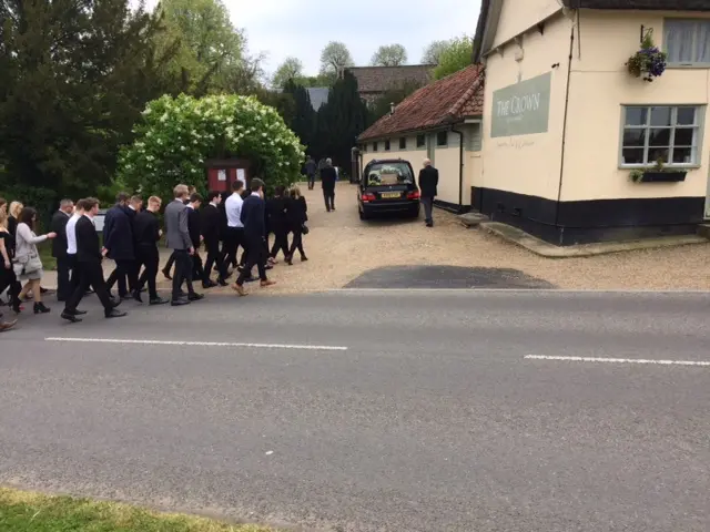 Crowds walk in the funeral cortege