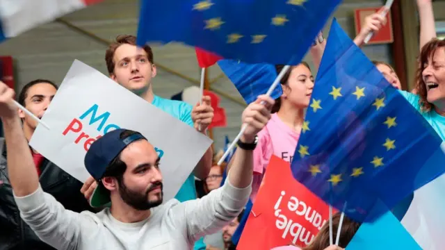 Macron supporter waves flags of the European Union, Paris, 1 May