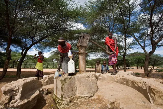 A Samburu family pump a well for fresh water nera their home in a village in the Samburu National Reserve