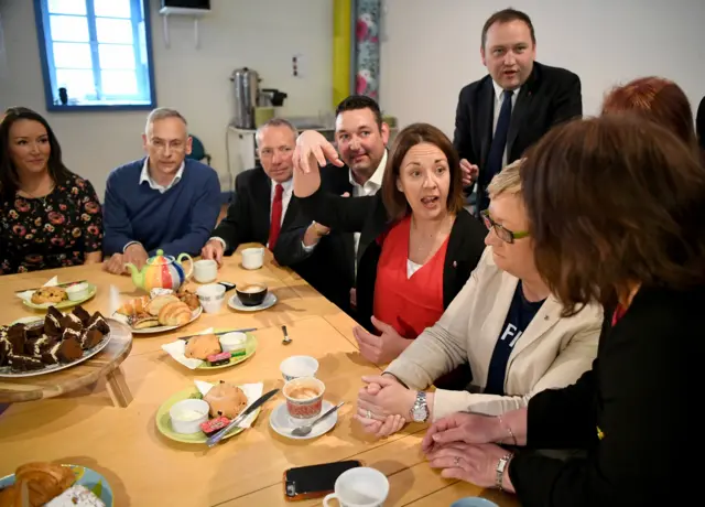 People sat around a table with cakes on it