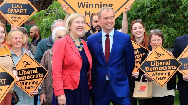 Tim Farron with Lib Dem supporters holding placards