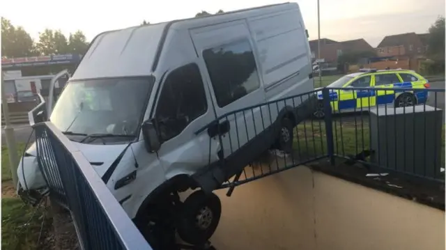 Van hanging over edge