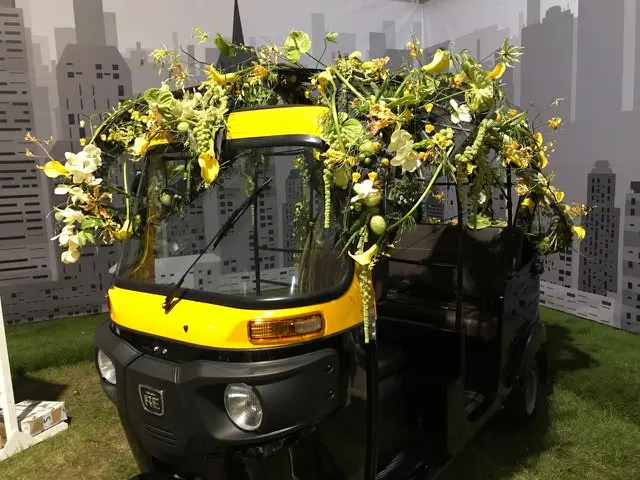 Yellow tuk tuk with flowers on the top