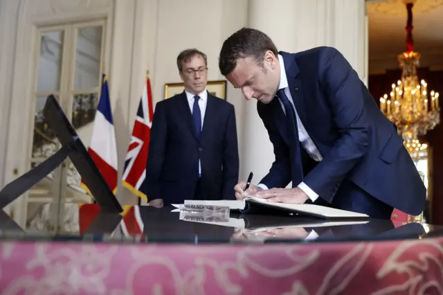 French president Emmanuel Macron signs condolence book