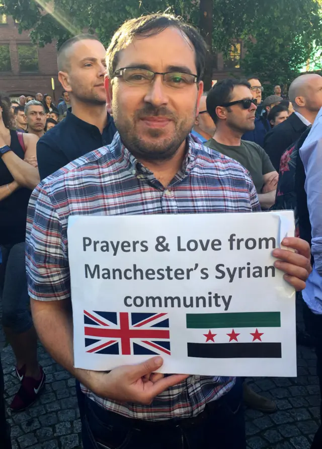 Man with sign at Manchester vigil