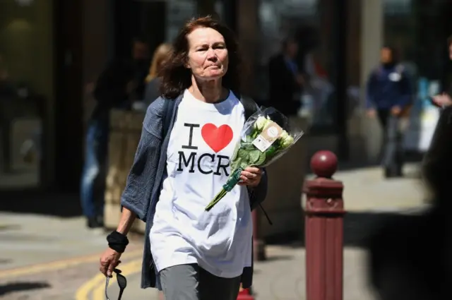 A woman laying flowers at Manchester's St Ann's Church