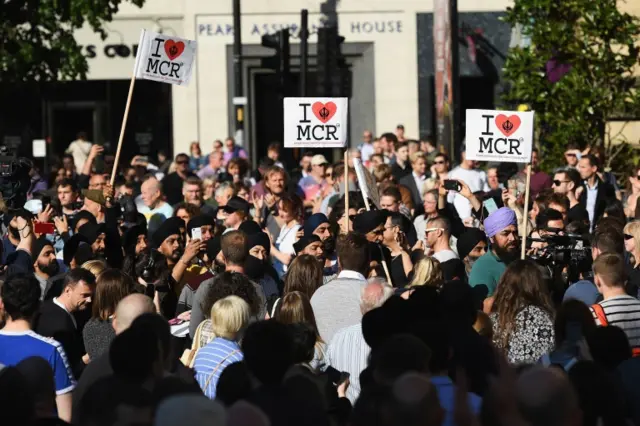 people hold signs at Manchester vigil