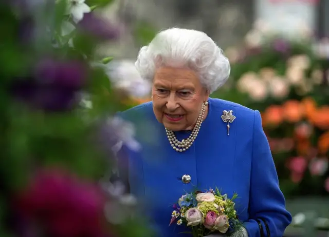 Queen Elizabeth holds some flowers