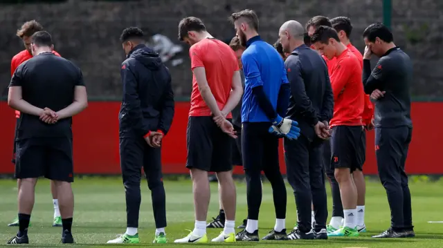 Manchester United players hold a minute's silence