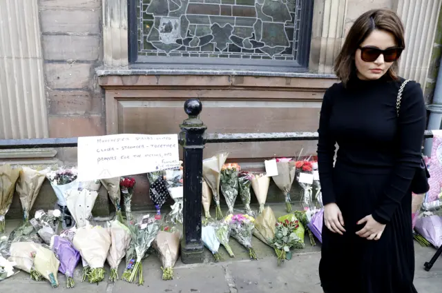 Woman laying flowers at St Ann's Church in Manchester