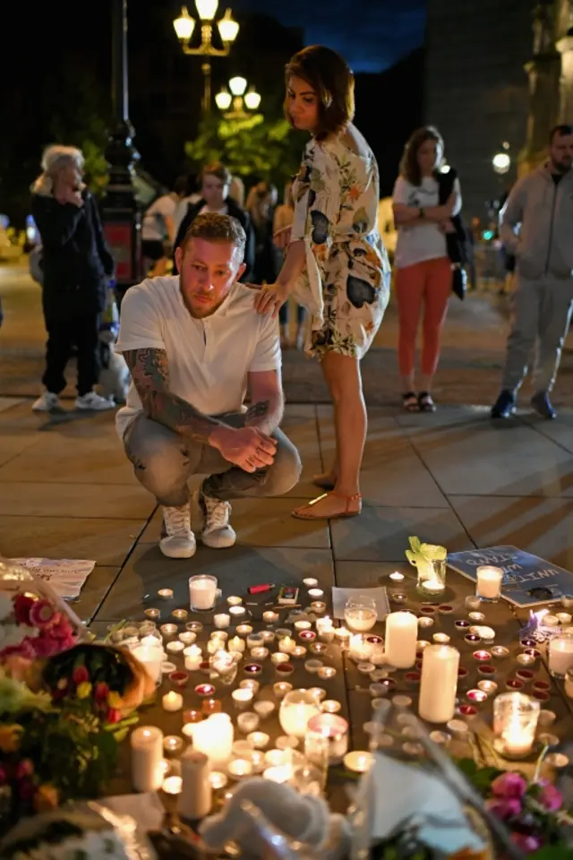 Members of the public attend a candlelit vigil at Albert Square in Manchester, 23 May