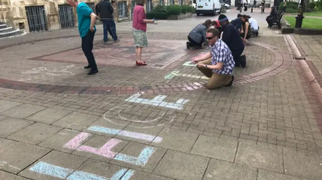 Chalking the pavement ahead of a vigil