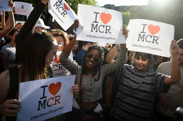 Young women hold banners at the vigil on Tuesday evening