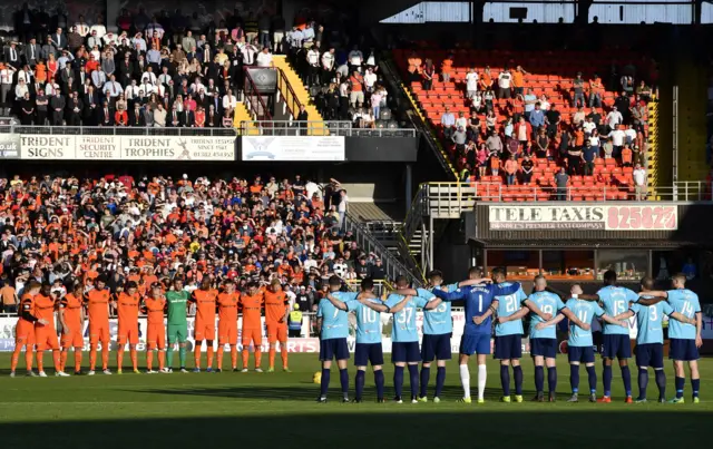 The players line-up for the minute's silence