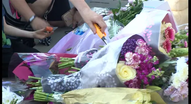 People laying flowers and lighting candles