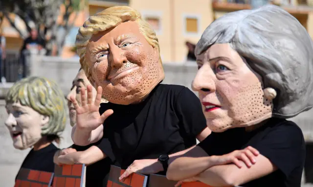 Protesters in Taromina, Sicily, wear masks of Theresa May, Donald Trump and other G7 leaders, 27 May