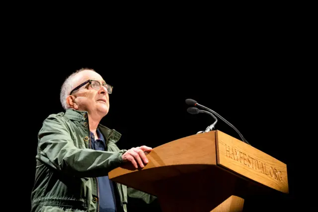 Tony Robinson reads a letter at the Hay Festival
