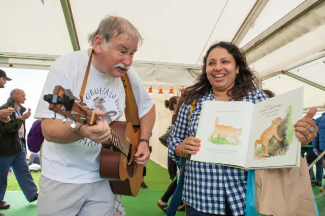 Malcolm Donaldson entertains a fan while she waits to meet Julia Donaldson