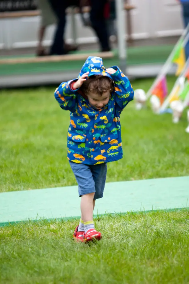 A child pulls up his hood at a rainy Hay Festival