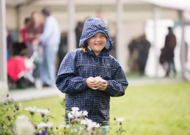 A smiling child at a rainy Hay Festival