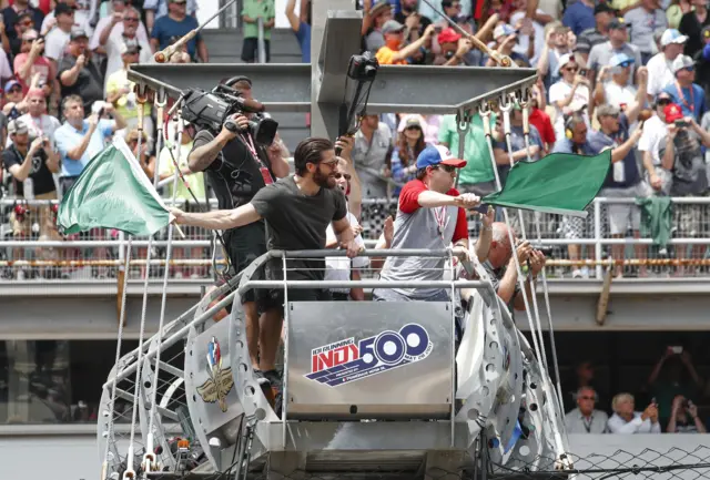 Jake Gyllenhaal (L) and Boston bombing survivor Jeff Bauman wave the green flags