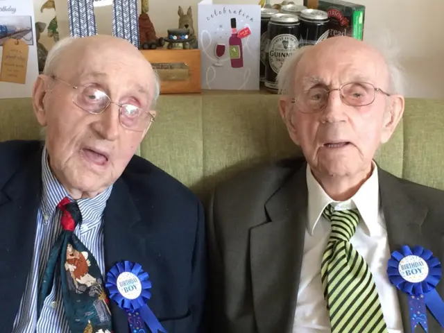 The twins, seated, with "Birthday Boy" blue rosettes on their lapels