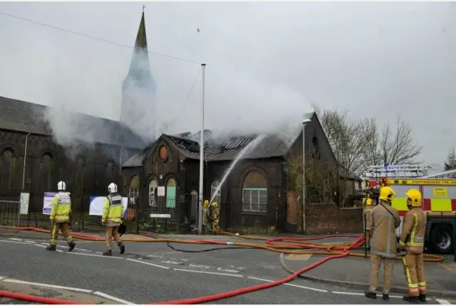 Fire officers tackling burnt building