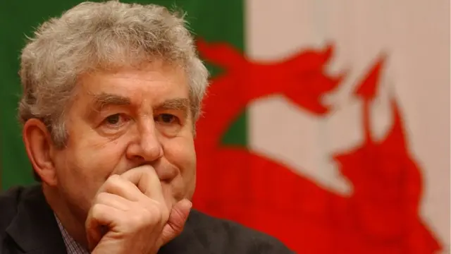 Rhodri Morgan in front of a Wales flag