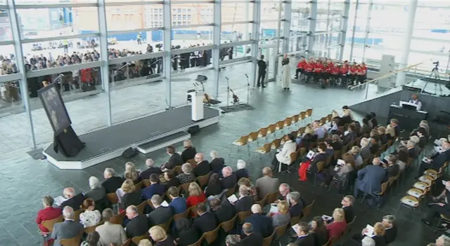 Mourners await the start of the ceremony at the Senedd