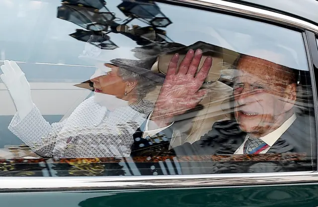 Prince Philip with the Queen waving from his car