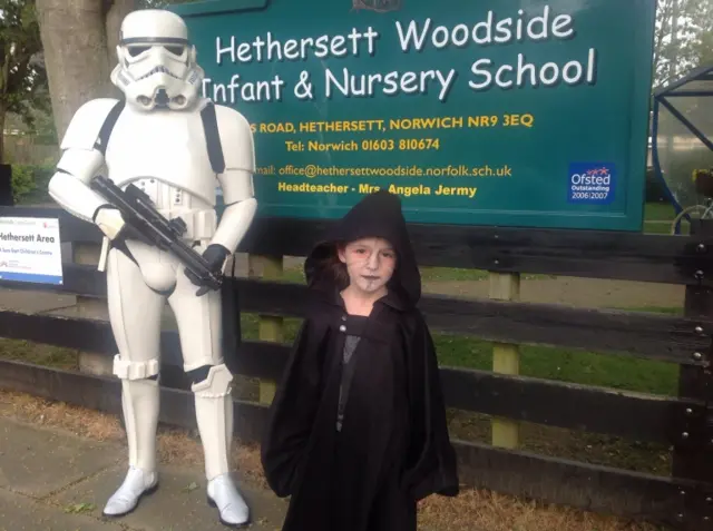 Adult in Storm troooper costume and child in a dark hooded Star Wars costume