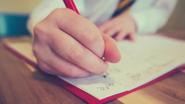 Student writing in a book