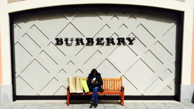 Woman sat outside Burberry shop