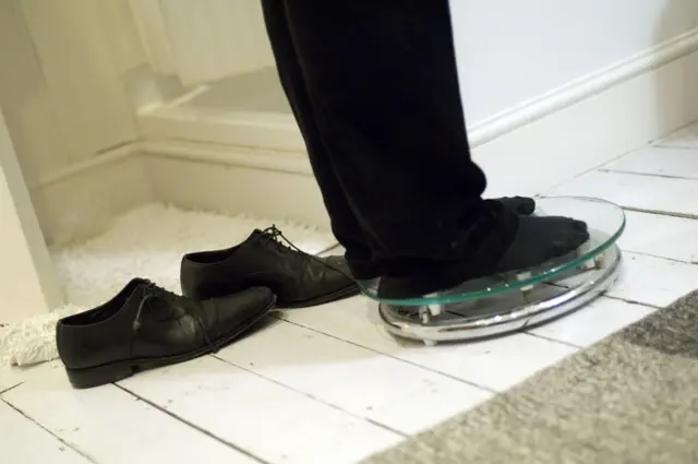 A man standing on a pair of bathroom scales