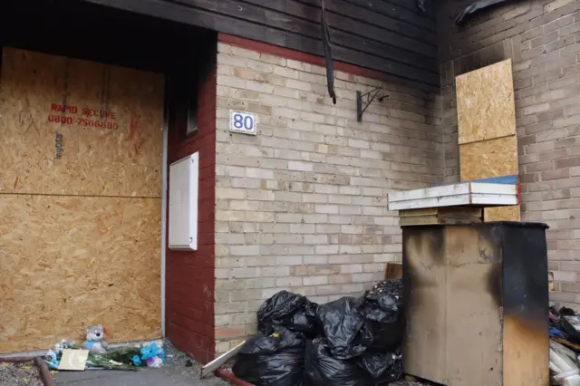 Flowers laid outside the fire-ravaged bungalow