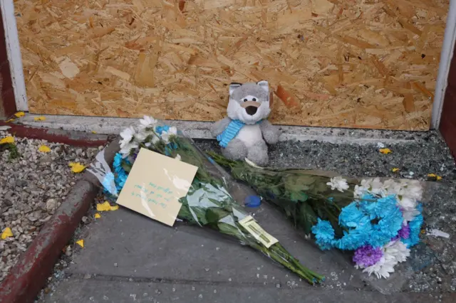 Flowers laid outside the fire-ravaged bungalow