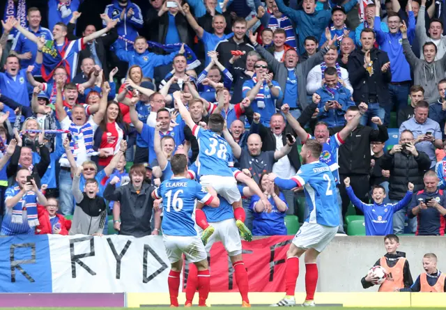 Linfield players celebrate in front of their fans after Andrew Waterworth's second goal