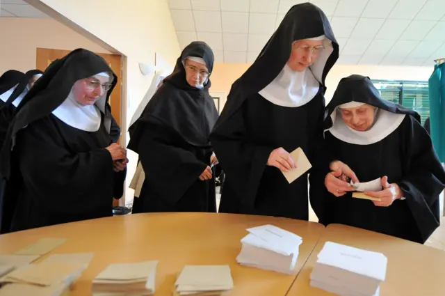 Benedictine Sisters of the Sainte-Cecile Abbey queue before voting at a polling station in Solesmes, northwestern France