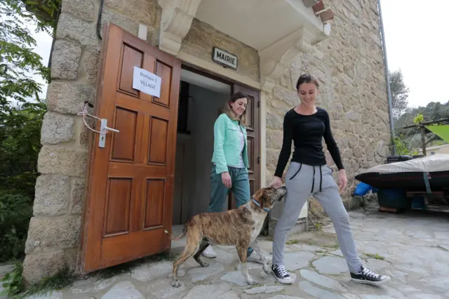 Women leave after voting at a polling station in the city hall of Pietrosella, Corsica, 7 May