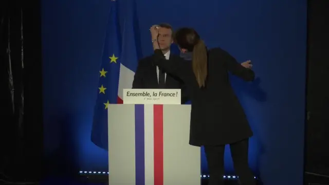 Macron getting makeup done