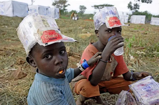 Newly arrived refugee children from South Sudan eat and drink at the Ngomoromo border post, in Ugandan side, on April 10, 2017.