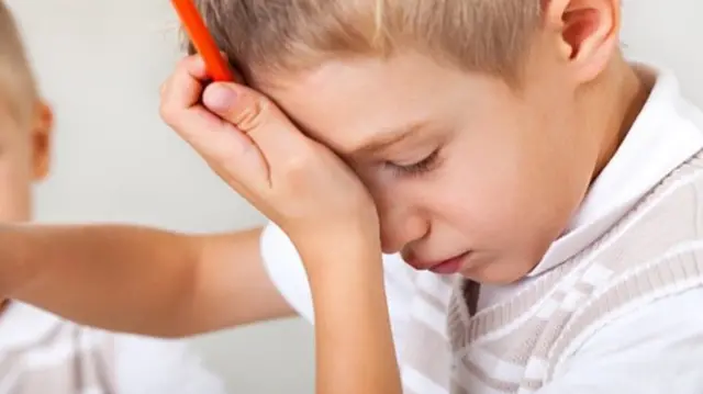 child with head against his palm