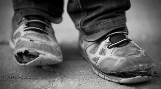 Child in ripped trainers