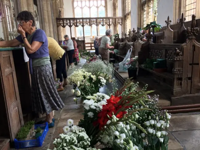 Interior of church, with women preparing the flower display