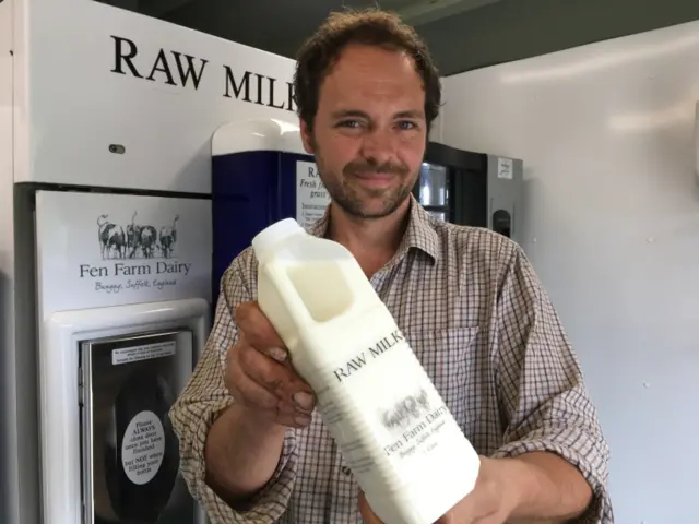 Johnny Crickmore holding a two-litre bottle of milk